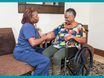 A health care professional talking blood presssure of woman in wheelchair