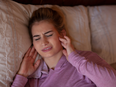 A woman holding her jaw. 