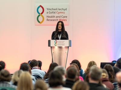 a_woman_with_brown_hair_presenting_at_a_conference