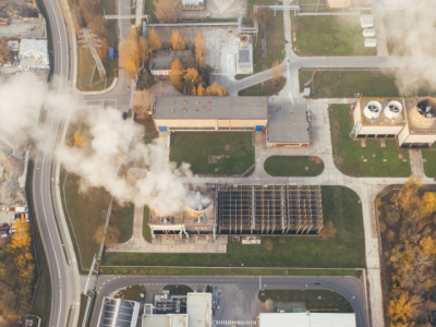 Photo looking down onto a power plant with a smoking chimney