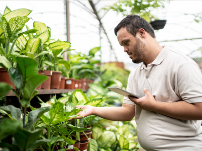 young man looking at plant 