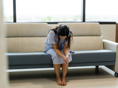 A woman sitting down in a waiting room. 