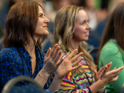 two_women_in_an_audience_clapping