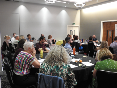 A group of people sitting around a table a discussing research. 