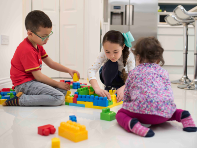 Three children on the floor playing with toys